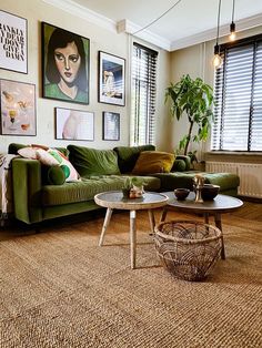 a living room with green couches and pictures on the wall above it's coffee table