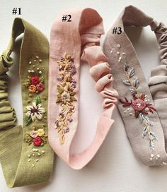 four different types of hair ties with flowers on the side and one has an embroidered flower