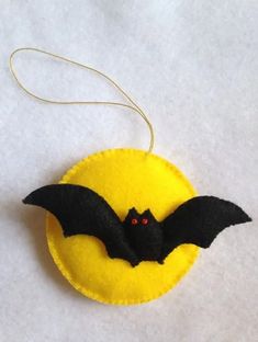 a bat ornament is hanging on a white tablecloth with a yellow circle