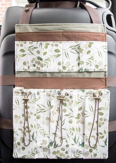 the back seat pocket has two ties hanging from it's sides and is decorated with green leaves