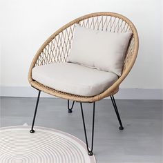 a wicker chair sitting on top of a white rug next to a round floor mat