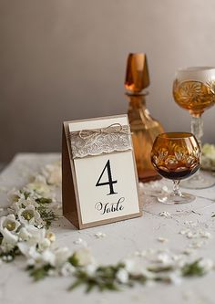 the table is set with wine glasses and place cards