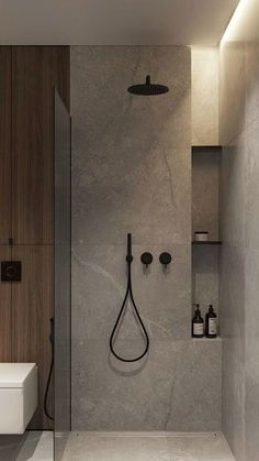 a bathroom with a walk in shower next to a white toilet and wooden wall mounted shelves