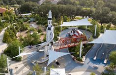 an aerial view of a park with a playground and water slide in the middle, surrounded by trees