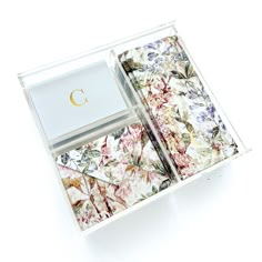 an open box with some flowers on it and a letter c in the bottom right corner