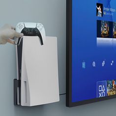 a person holding a video game controller in front of a large screen tv with the microsoft logo on it