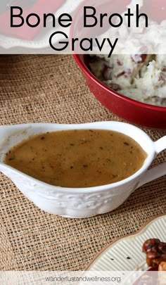 a bowl of gravy next to a plate of chicken and mashed potatoes