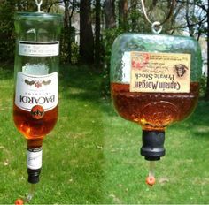 there are two wine glasses hanging from the side of a bird feeder, and one is filled with alcohol