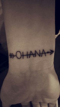 a person's foot with an arrow and the word ohana tattooed on it