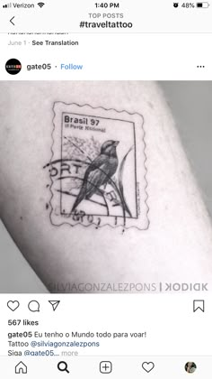 a small tattoo on the arm of a person with a bird stamp in front of them