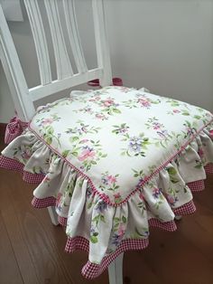 a white chair with a pink and green flowered seat cover on top of it