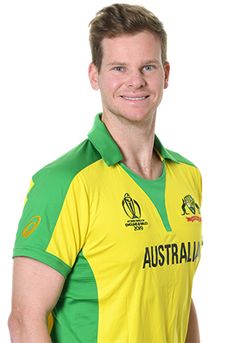 a man in a yellow and green shirt posing for the camera with his hands on his hips