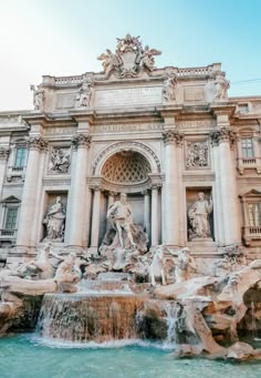 an ornate building with statues and water fountain