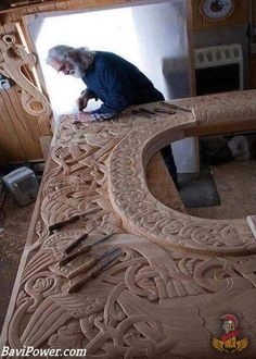 a man working on an intricately carved bench