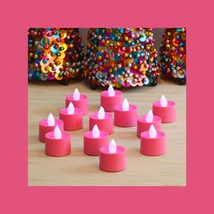 small pink candles sitting on top of a wooden table