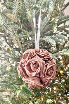 an ornament hanging from a christmas tree decorated with pink roses and silver ribbon