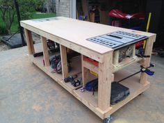 a workbench with tools and equipment on it in front of a garage door