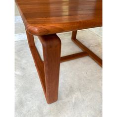 a wooden table sitting on top of a white carpeted floor next to a wall