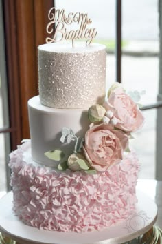 a three tiered cake with pink flowers on top