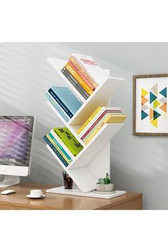 a computer monitor sitting on top of a desk next to a bookshelf filled with books