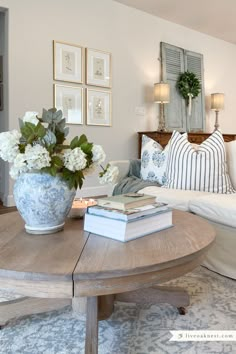 a living room filled with furniture and flowers on top of a coffee table in front of a couch