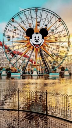 an amusement park with a ferris wheel and mickey mouse face