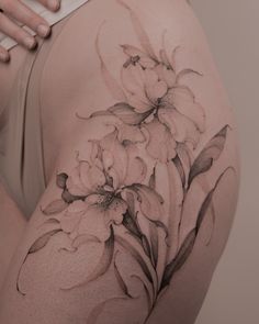 a woman's thigh with flowers painted on it and her arm behind her back