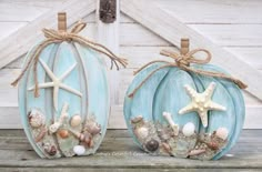 two pumpkins decorated with seashells and starfish