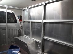 the interior of a vehicle with stainless steel panels on the wall and door, along with other vehicles