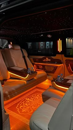 the interior of a luxury car with its lights on and leather seats in front of it