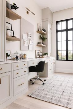 an office with white walls and drawers, a rug on the floor in front of it