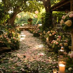 an outdoor wedding venue with flowers and candles on the ground, surrounded by greenery