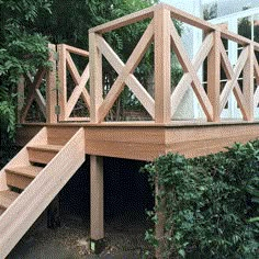 there is a wooden staircase going up the side of a house with trees in the background