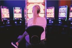 a woman sitting in front of slot machines