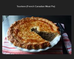 a meat pie on a plate with a knife and fork