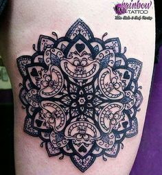 a black and white tattoo design on the thigh with an intricate flower in the center