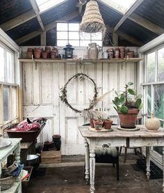 a room filled with lots of potted plants on top of wooden tables and chairs