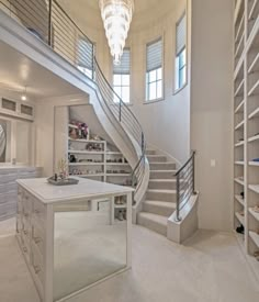 a very large room with some shelves and a chandelier hanging from the ceiling