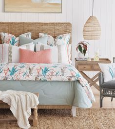 a bed with pillows and blankets on top of it in a room next to a chair