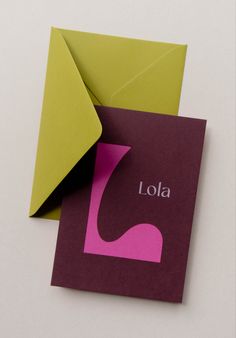 two folded cards with the word lola printed on one side and an envelope in the other