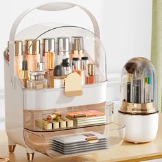 an organized makeup organizer on a table with gold accessories and other personal care items in it