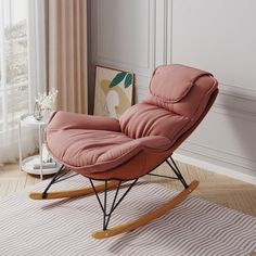 a pink chair sitting on top of a wooden floor next to a white and beige rug