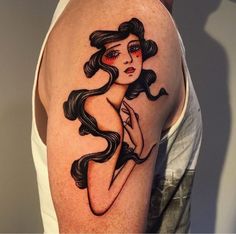 a woman's arm with a black and red tattoo design on the left shoulder