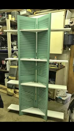 an open green shuttered shelf in a garage