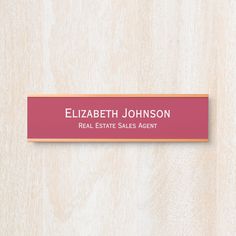 a real estate sales agent sign mounted on a wood paneled wall with the name elizabeth johnson