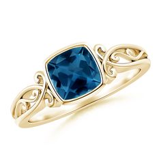 a gold ring with a blue topazte stone in the center and filigrees on the sides