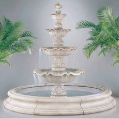 a white fountain with three fountains and palm trees in the backgrounnds