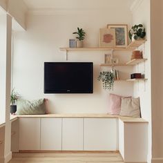 a flat screen tv mounted to the side of a wall next to a wooden bench