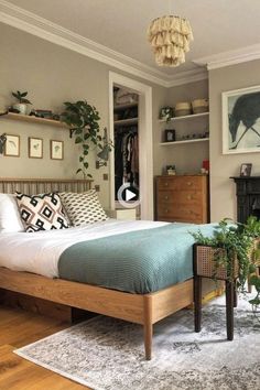 a bed sitting in a bedroom next to a wooden dresser under a hanging planter