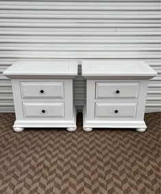 two white dressers side by side with drawers on each end and one drawer open